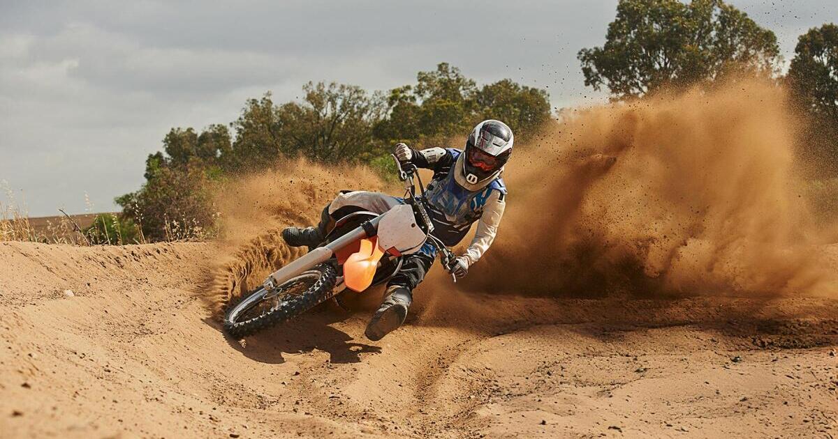 A dirt bike rider riding in the wild land with full body protection equipment