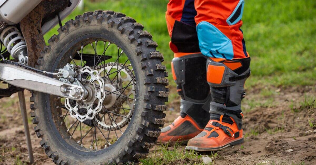 A dirt bike rider wearing riding boots